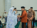 h. maulana didampingi istri saat serahkan paket sembako kepada warga simpang tiga sipin.