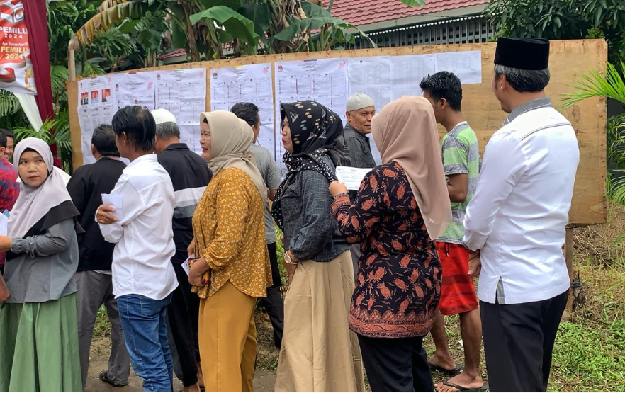 tampak ketua dprd provinsi jambi, edi purwanto bersama istri mengantri ditengah tengah masyarakat saat hendak mencoblos di tps.